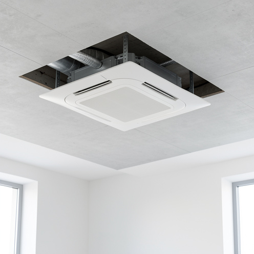 Cassette de climatisation extra-plate intégrée dans un plafond moderne, avec une vue sur son installation et son faible encombrement.