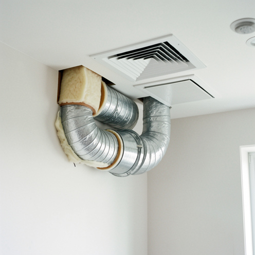 Gaines isolées de ventilation mécanique contrôlée montrant différents diamètres, leur raccordement et leur couche d’isolation dans un environnement résidentiel.